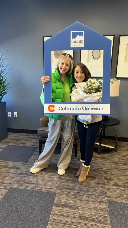 New homeowner with flowers in a "Colorado Homeowner" frame with Tamila Aspen